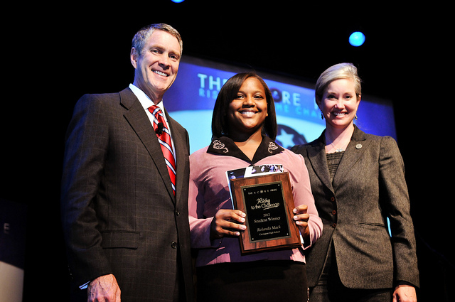 Three educators smiling at camera, with woman in the middle holding an award 6